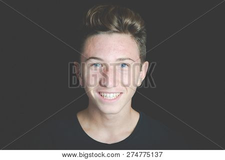 Young Smiling Boy Portrait On Black Background - Concept Of Adolescence Whithout Problems