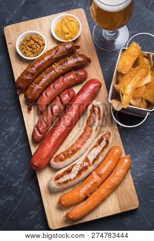 Grilled german sausages with mustard and fried potato chips