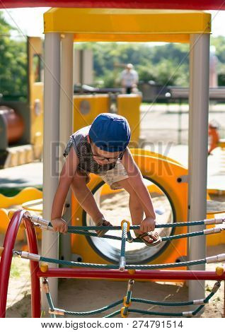 Poznan, Poland - July 29, 2018: Young Boy Climbing On A Equipment At A Playground In The Cytadela Pa