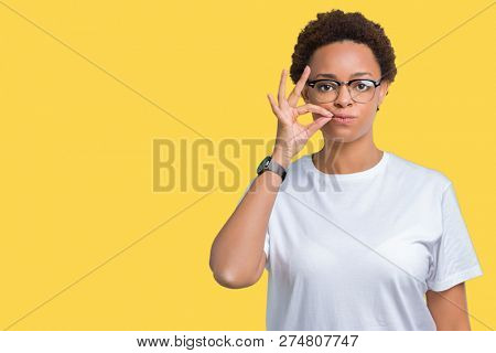 Beautiful young african american woman wearing glasses over isolated background mouth and lips shut as zip with fingers. Secret and silent, taboo talking