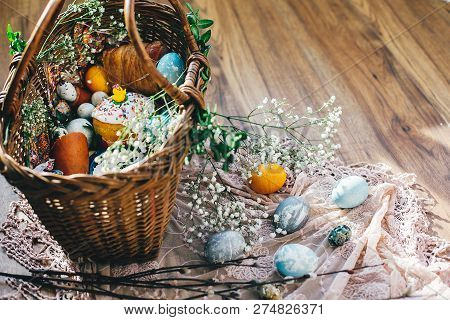 Easter Basket With Eggs, Easter Bread,ham,sausage, Butter With Flowers And Branches On Cloth On Rust