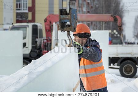 Slinger In An Orange Helmet On Unloading Ice Blocks