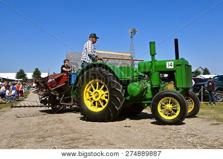 Pekin, North Dakota, September 2, 2018: An Old Restored D Two Cylinder John Deere Tractor Pulling A 