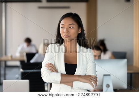 Serious Asian Female Employee Standing In Coworking Office And T