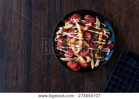 Homemade Peruvian Salchipapa Fries With Sausage Slices, Ketchup And Mayonnaise.