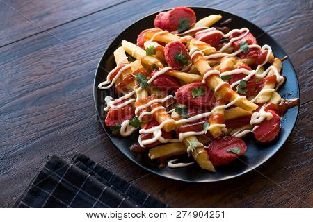 Homemade Peruvian Salchipapa Fries With Sausage Slices, Ketchup And Mayonnaise.