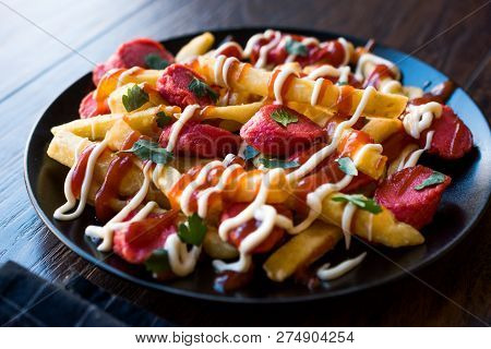 Homemade Peruvian Salchipapa Fries With Sausage Slices, Ketchup And Mayonnaise.