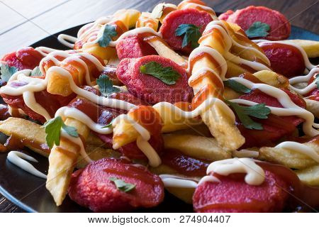 Homemade Peruvian Salchipapa Fries With Sausage Slices, Ketchup And Mayonnaise.