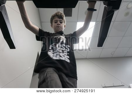 Young Person Engaged In Physical Activity At A Gym Walking On Treadmill From Low Angle.