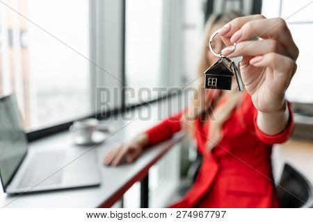 Mortgage Concept. Woman In Red Coral Business Suit Holding Key With House Shaped Keychain. Modern Li