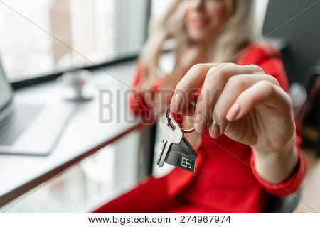 Mortgage Concept. Woman In Red Coral Business Suit Holding Key With House Shaped Keychain. Modern Li
