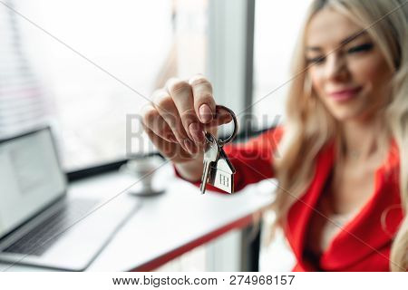 Mortgage Concept. Woman In Red Coral Business Suit Holding Key With House Shaped Keychain. Modern Li