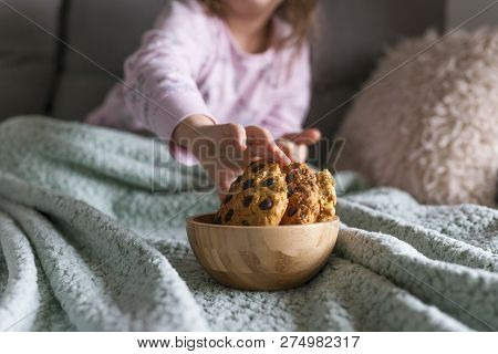 The Girl Has A Delicious Chocolate Biscuit Breakfast. The Child Is Sitting On Dwan. Home Comfort And