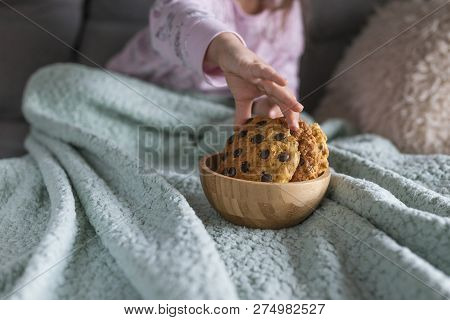The Girl Has A Delicious Chocolate Biscuit Breakfast. The Child Is Sitting On Dwan. Home Comfort And