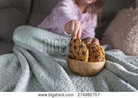The Girl Has A Delicious Chocolate Biscuit Breakfast. The Child Is Sitting On Dwan. Home Comfort And