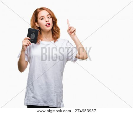 Young beautiful woman holding passport of canada over isolated background surprised with an idea or question pointing finger with happy face, number one