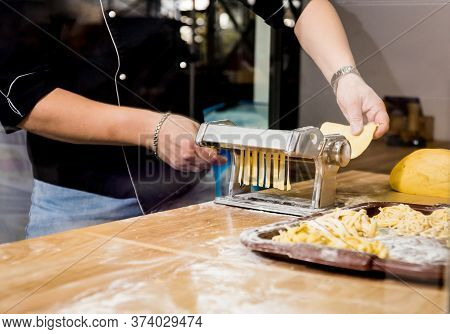Chef Rolling Dough With A Pasta Machine. Pasta Maker Machine.