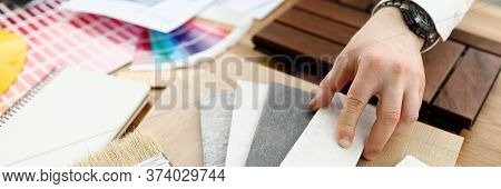 Male Designer Hand Hold Silver Pen Against Color Palette Trend Closeup Background. Building Material