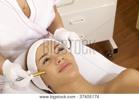 Mladá bruneta žena přijímá laserové terapie. Wellness studio zastřelil