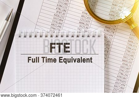 On The Table Are Financial Reports, A Pen, A Magnifying Glass And A Notebook With The Inscription -f