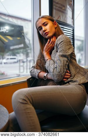 Girl In Grey Suit Posing In Cafe Interior