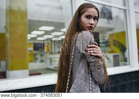 Girl In Grey Suit Posing In Front Of The Show-window