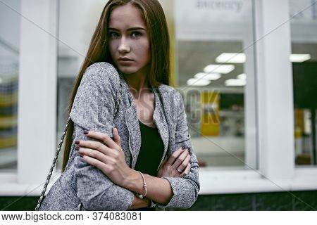 Girl In Grey Suit Posing In Front Of The Show-window