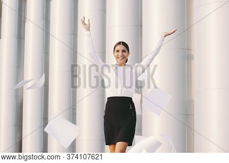 Happy Beautiful Business Woman In Suit Throw Up Papers Away And Smile Outdoors. Cheerful Young Attra