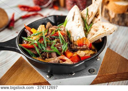 Closeup On Mexican Dish Fajitos With Beef Vegetables And Pita In A Pan, Horizontal