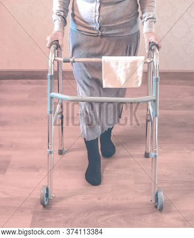 Old Wrinkled Hands On Walking Frame. Hands Of A Standing Senior Woman Leaning On A Rollator. Pension