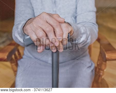 Old Wrinkled Hands On Walking Frame. Hands Of A Standing Senior Woman Leaning On A Rollator. Pension