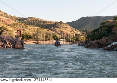 The Kunene River Below The Epupa Waterfalls. A Flood Level Monitor Tower Is Visible