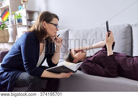 Young Woman At Consultation With Psychologist. Female Patient Lying On Couch Talking About Mental Pr