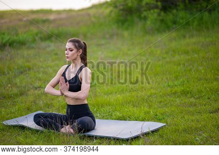 Fitness And Lifestyle Concept - Woman Doing Yoga In Nature