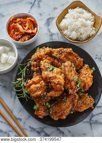 crispy fried korean chicken wings in galbi sauce with pickled radish, kimchi, and rice side dishes