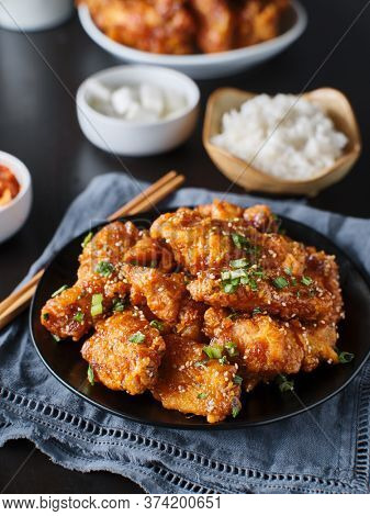 crispy fried korean chicken wings in galbi sauce with pickled radish, kimchi, and rice side dishes