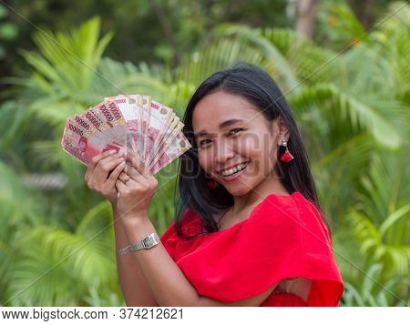 Indonesian Money In The Hands Of An Asian Girl.
