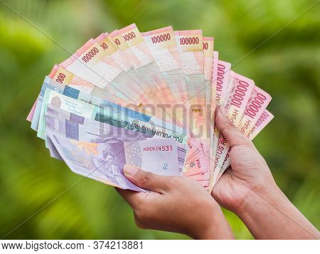 Indonesian Money In The Hands Of An Asian Girl.