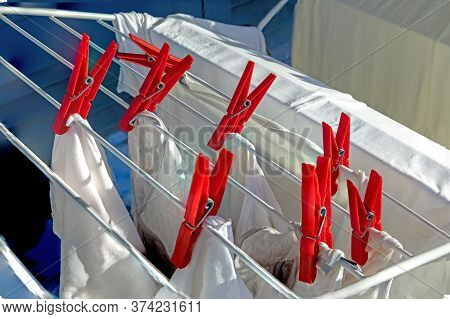 Red Peg At Clothesline With White Clothes As Symbol Of Cleaness