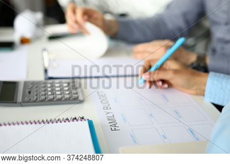 Close-up Of People Planning Family Budget. Calculator And Notebook On Table. Earning And Expenses Fo