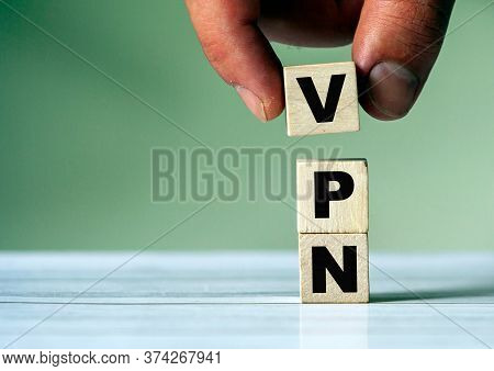 The Hand Puts The Cube Block With The Inscription Vpn. Vpn Concept And Background.