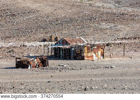 Traditional African Hut From Rusty Sheet Of Tin In Desert Of Erongo Region. In Background Is Brandbe