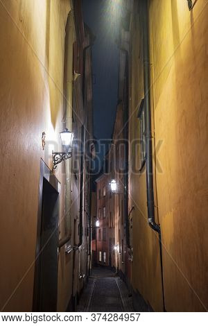 A Verticle Image Of A Narow Alley In Gamla Stan, Stockholm, Sweden's Old Town, With Colorful 17th An