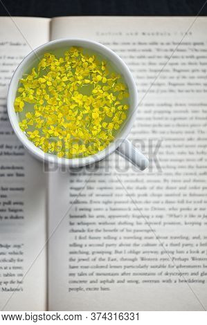 Closeup Cup Of Herbal Drink On Open Book