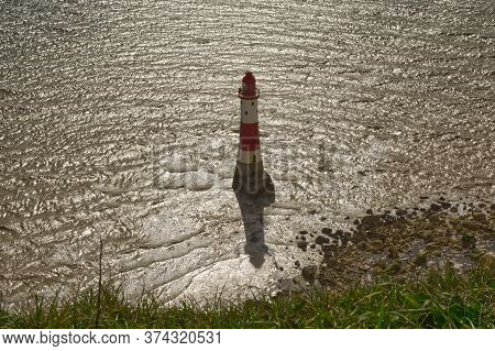 View Down To Lighthouse In Sea At Beachy Head. South Downs, Near Eastbourne In East Sussex, England