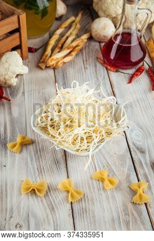 Fiber Smoked Cheese Chechil In A Bowl On The White Wooden Table, Vertical