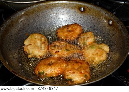South Indian Cuisine - Vada Or Medu Vadai Frying In Coconut Oil. Very Popular South Indian Snack.