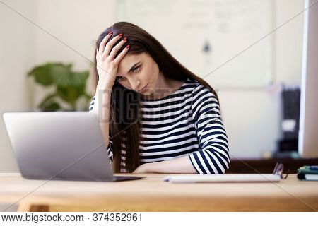 Stressed Businesswoman Working On Laptop At Home
