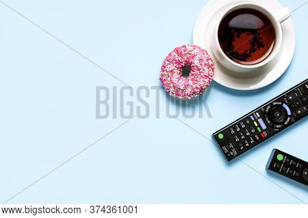 Black Tv, Audio Remote Control, Cup Of Tea, Pink Sweet Donut On Blue Background Flat Lay Top View Co