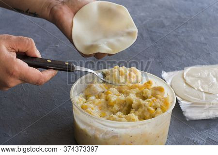 A Hand About To Filling A Dough Of Empanadas With Corn's Cream. Argentinian Food.